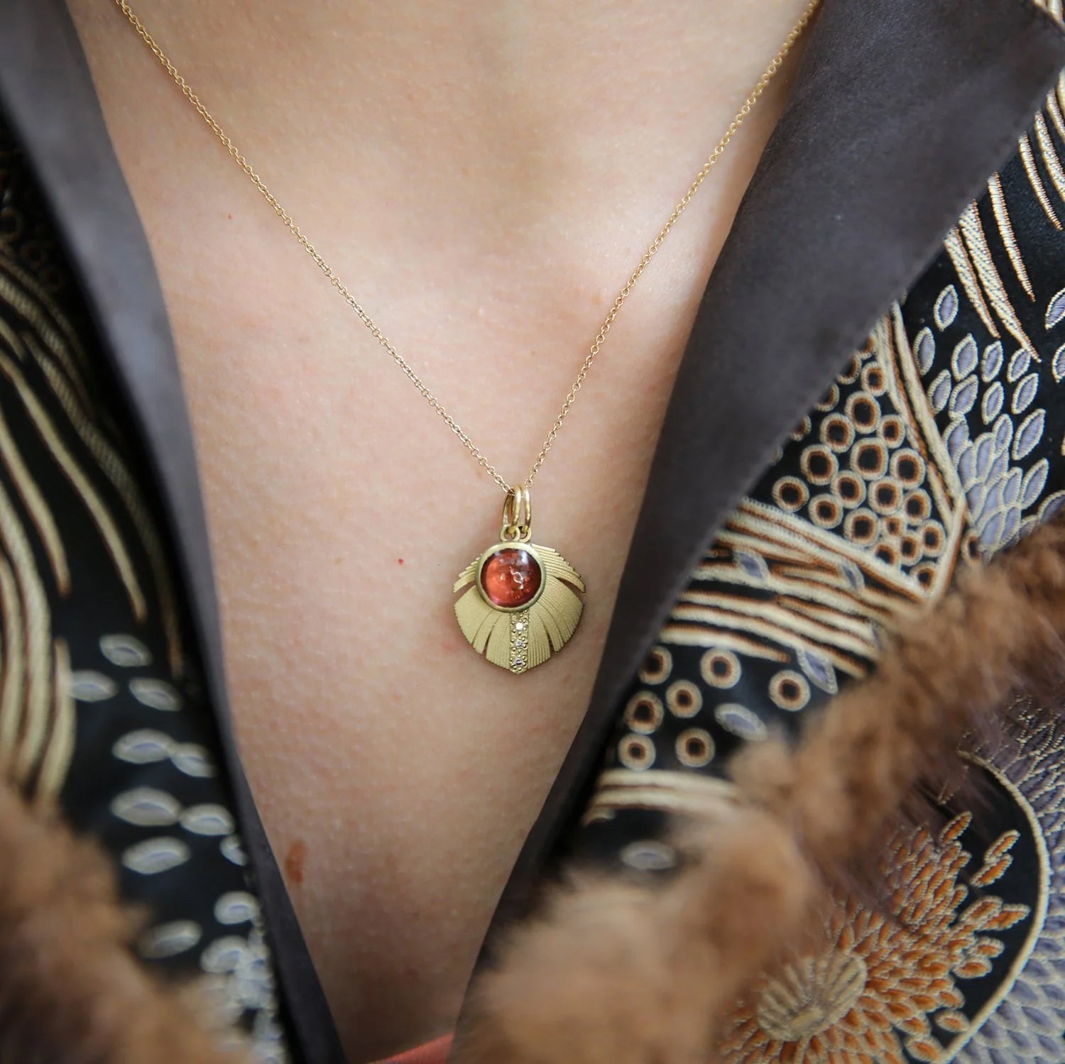 Wide Gold & Diamond Feather Charm on Gold Chain + Pink Tourmaline Cabochon Charm on white female model in brocade jacket | Rebecca Myers Collection