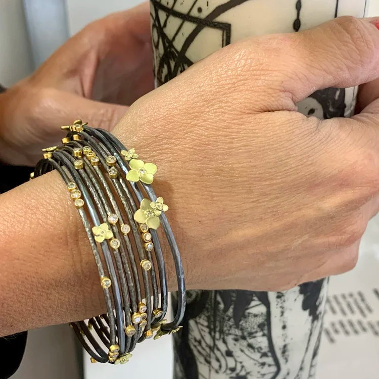 Gold, Silver & Diamond Branch Bangles on white female model holding vase | Rebecca Myers Collection