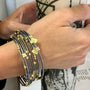 Gold, Silver & Diamond Branch Bangles on white female model holding vase | Rebecca Myers Collection