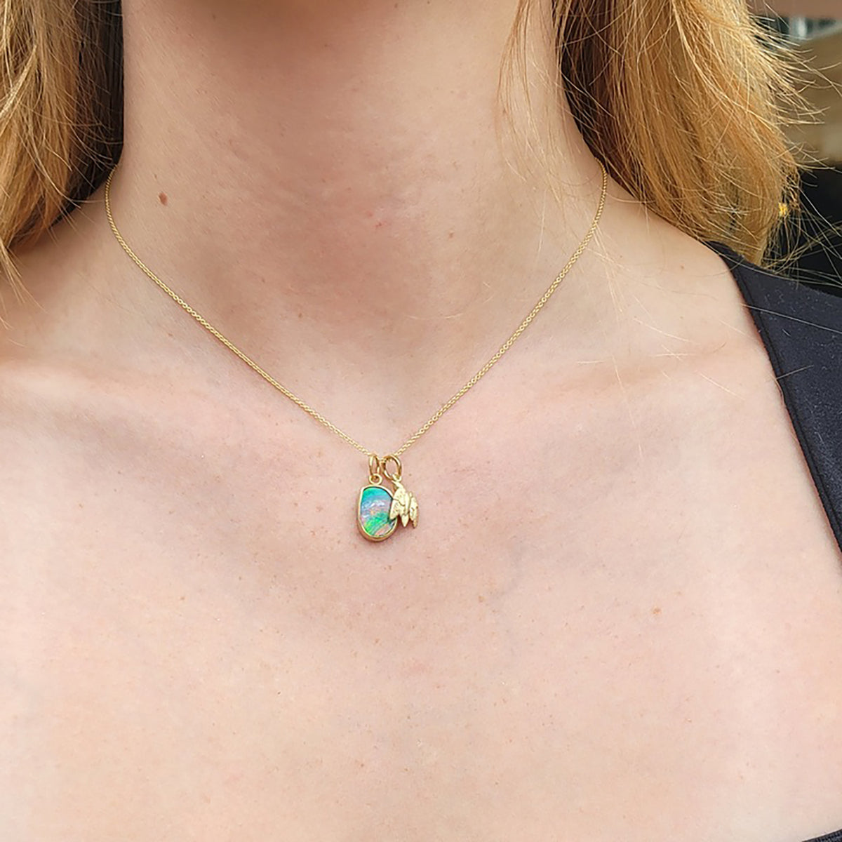 Medium Oblong Rainbow Boulder Opal Charm & Medium Gold Bird Charm on white female | Rebecca Myers Collection