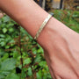 Hinged Feather Bracelet white female model against greenery | Rebecca Myers Collection