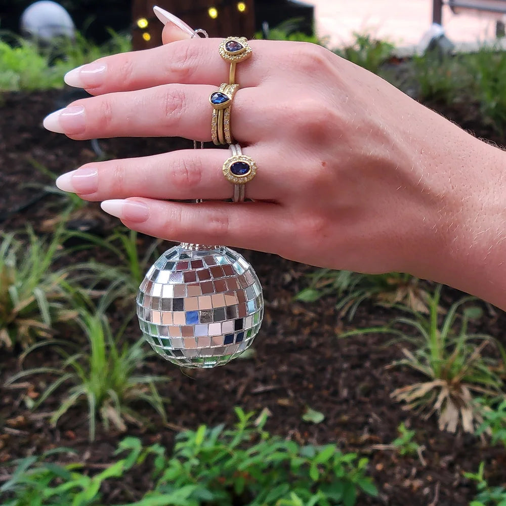 Gemmie Halo Rings on Gold or Silver Bands on white female model holding mirrored ball ornament | Rebecca Myer Design