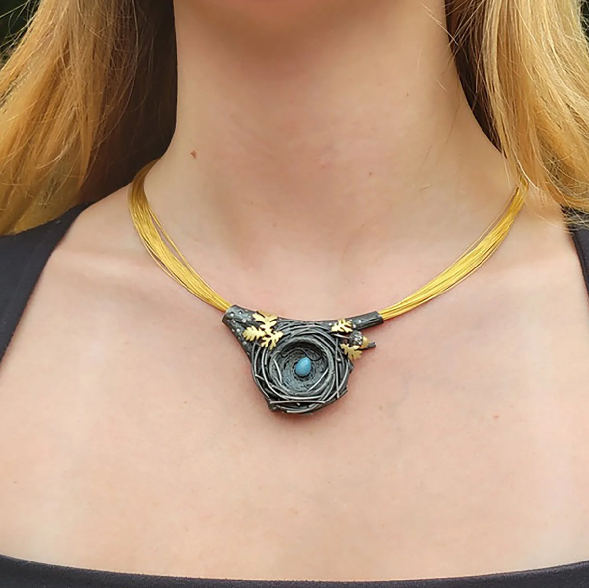 Large Nest Pendant Coil Necklace with Blue Egg & Oak Leaves on white female model | Rebecca Myers Collection