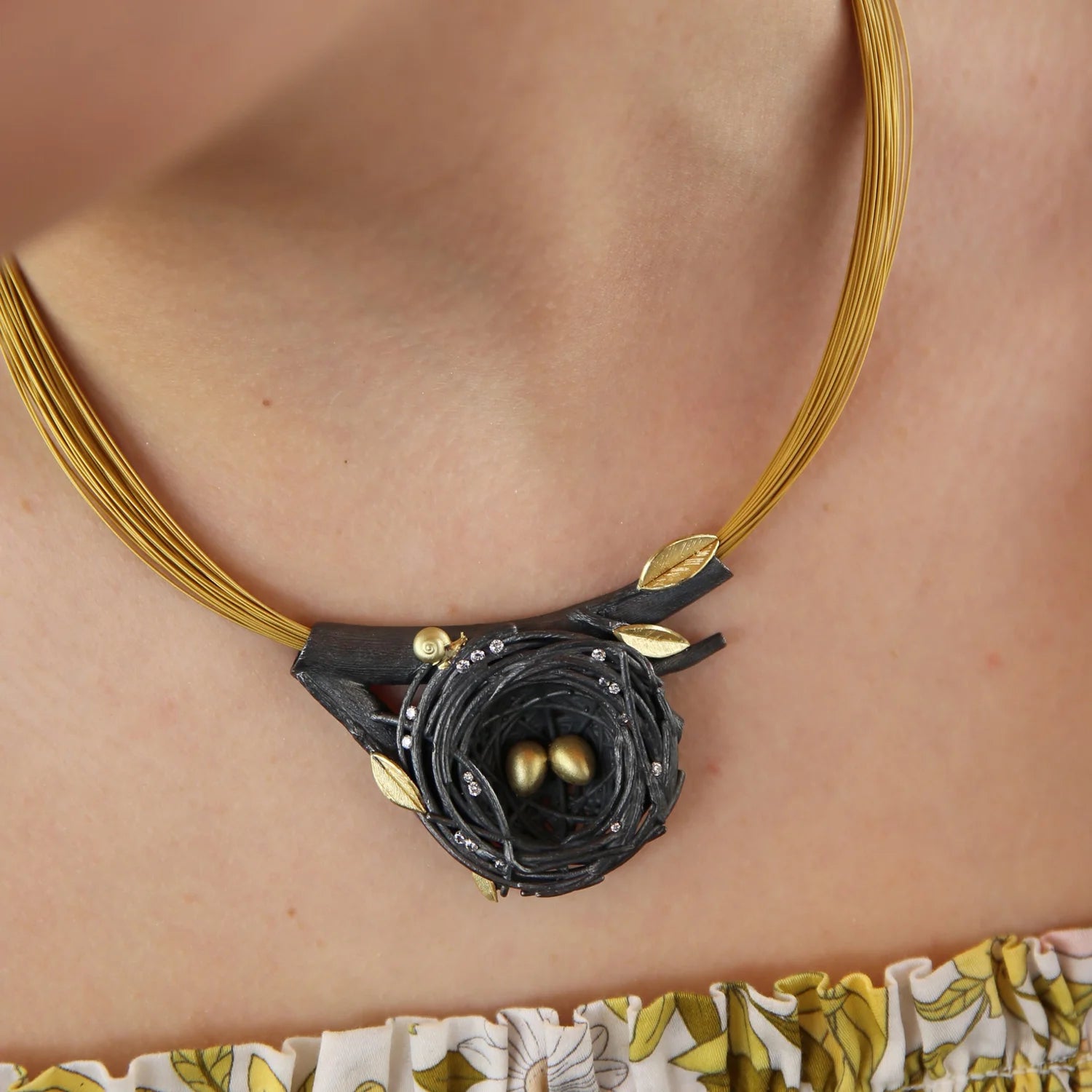 Large Nest Pendant Coil Necklace with Gold Eggs, Leaves, & Snail on white female model | Rebecca Myers Collection