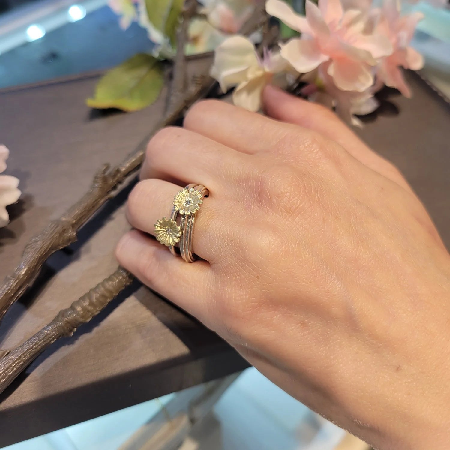 Shasta Daisy Stacking Rings on white female model holding flowers | Rebecca Myers Collection